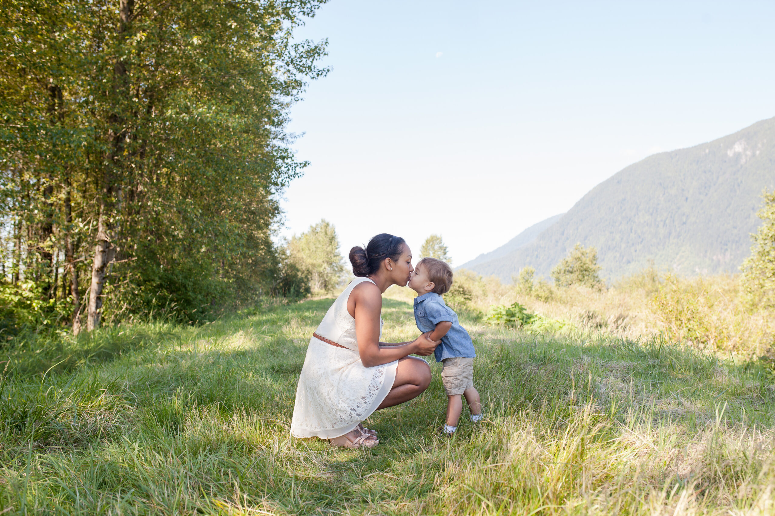 Mom kissing her son in a field