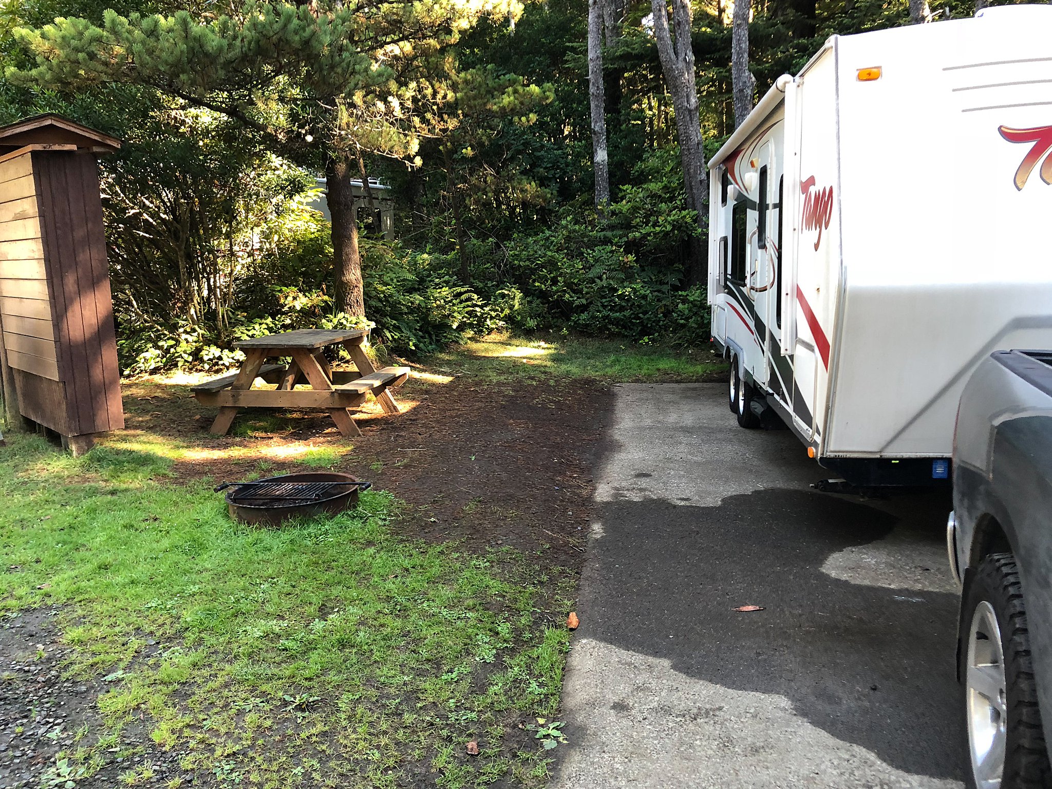An RV sits parked at a campsite with a picnic table and fire pit RV Rental Okanagan