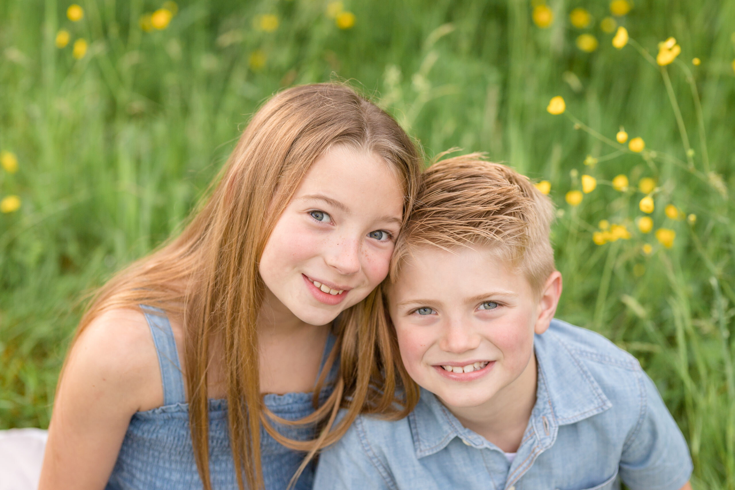 siblings wearing blue in a wildflower field