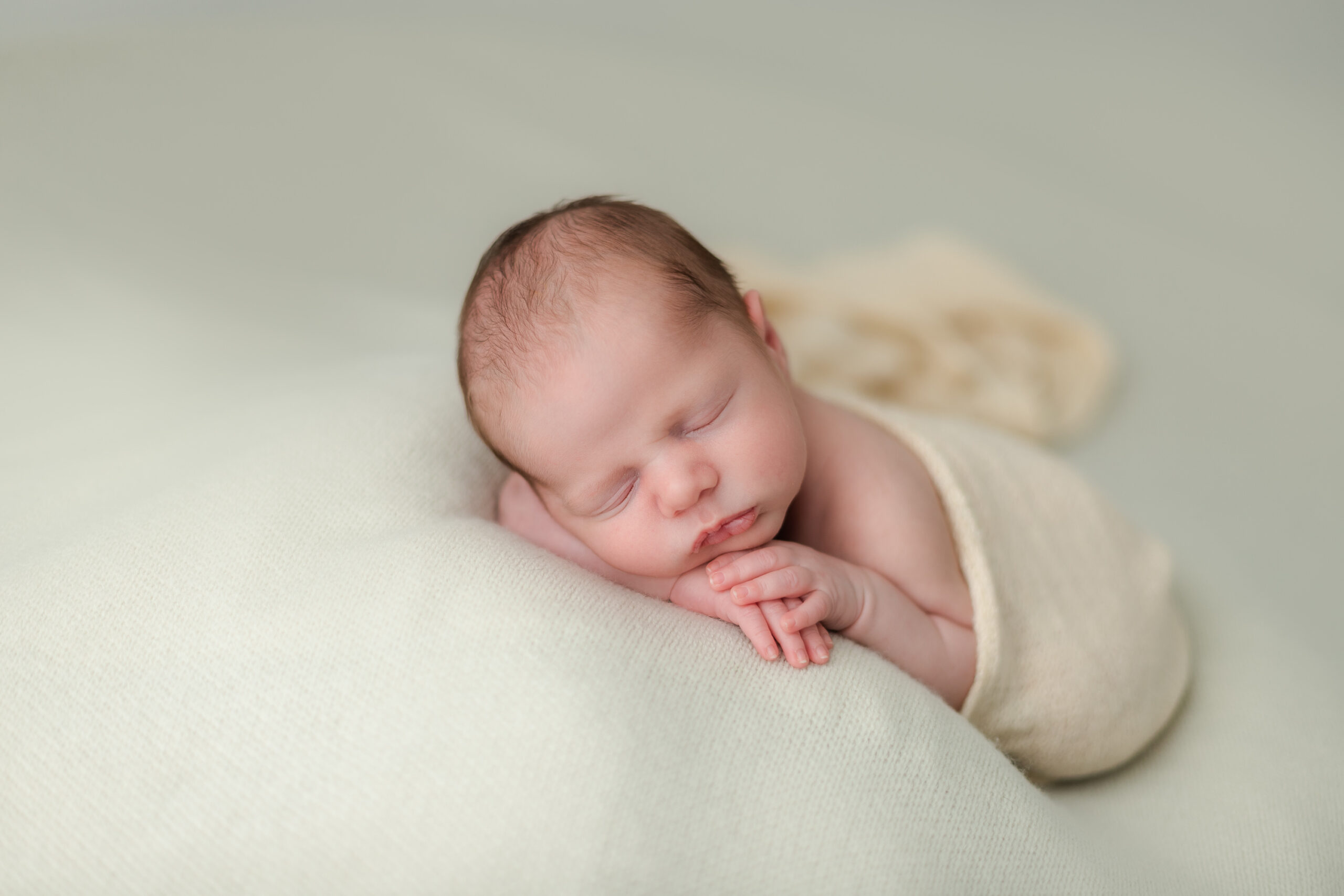 sweet newborn baby posed on a yellow blanket