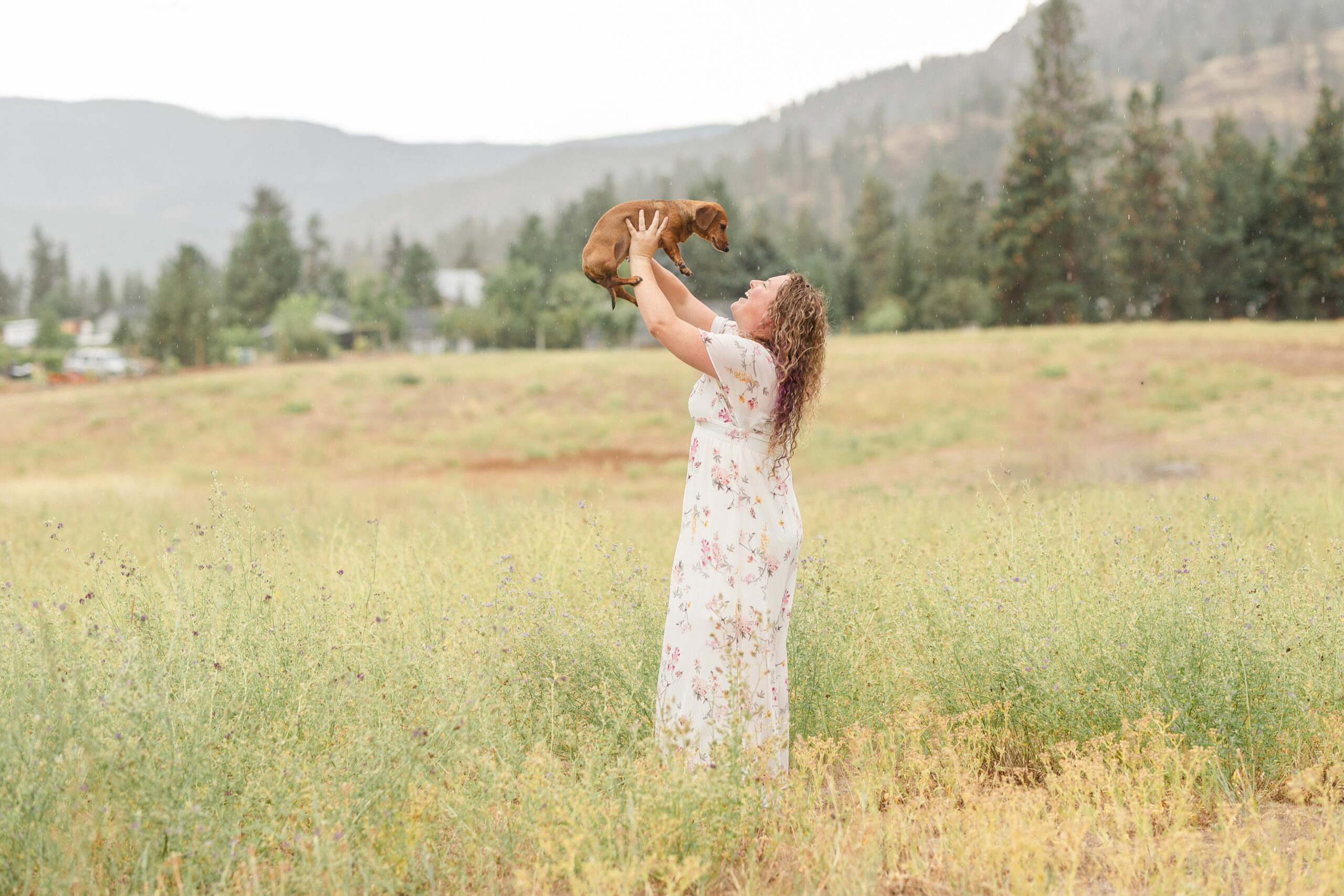 beautiful mama in a kelowna field wearing a dress with her weiner dog