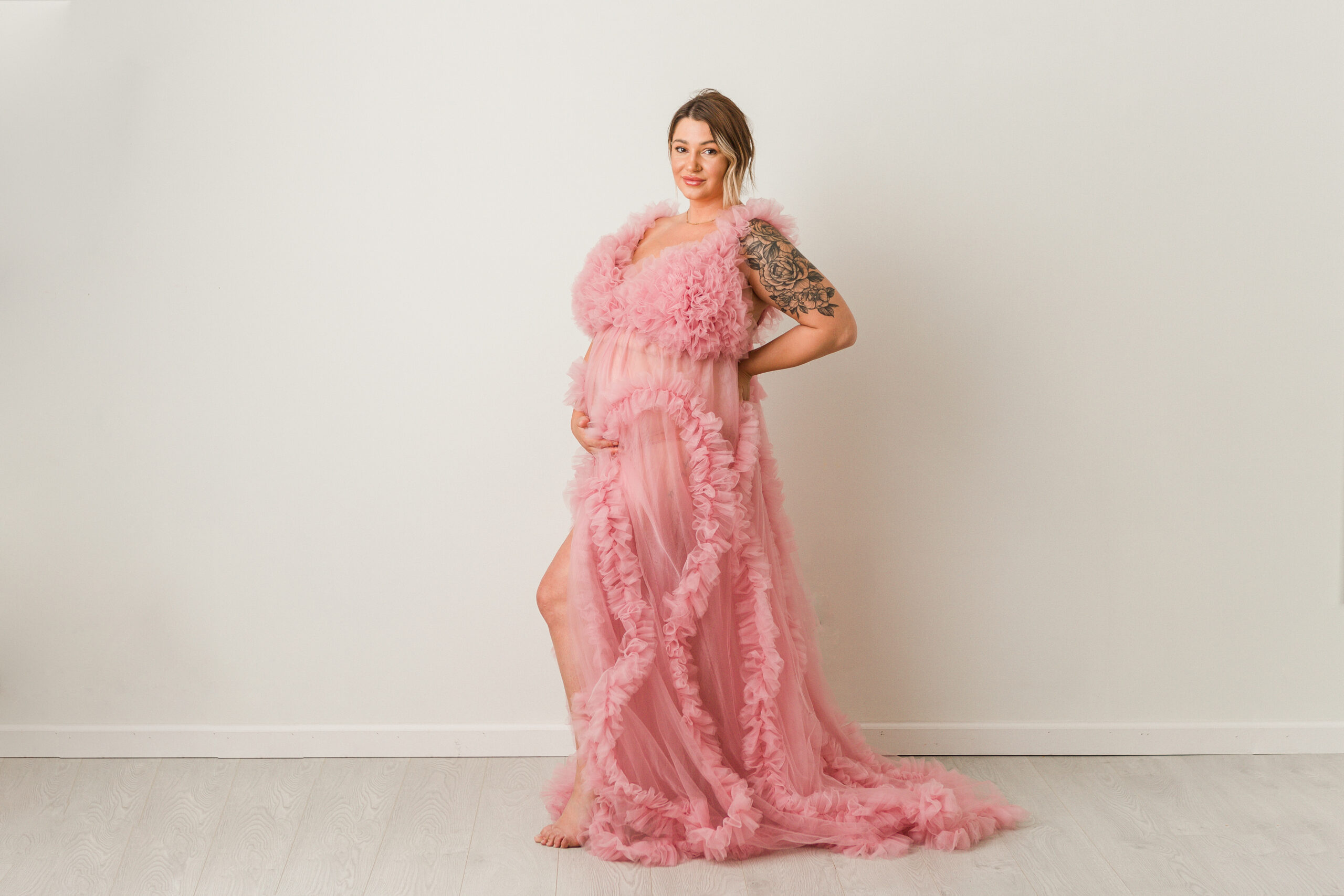 stunning mom to be in a kelowna photography studio wearing a pink gown